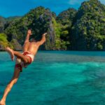 Man jumping clear blue water in Coron