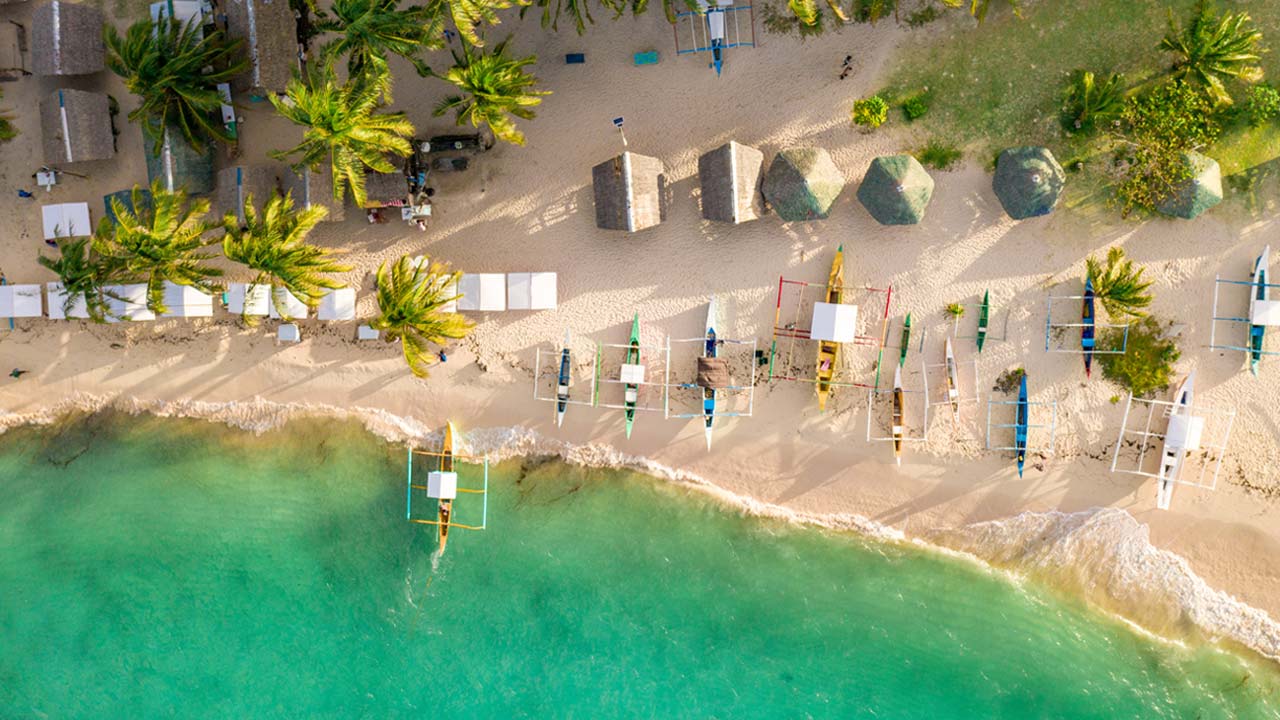 Aerial view of Siargao island coastline with palm trees, Philippines - Siargao vs Boracay comparison 2026