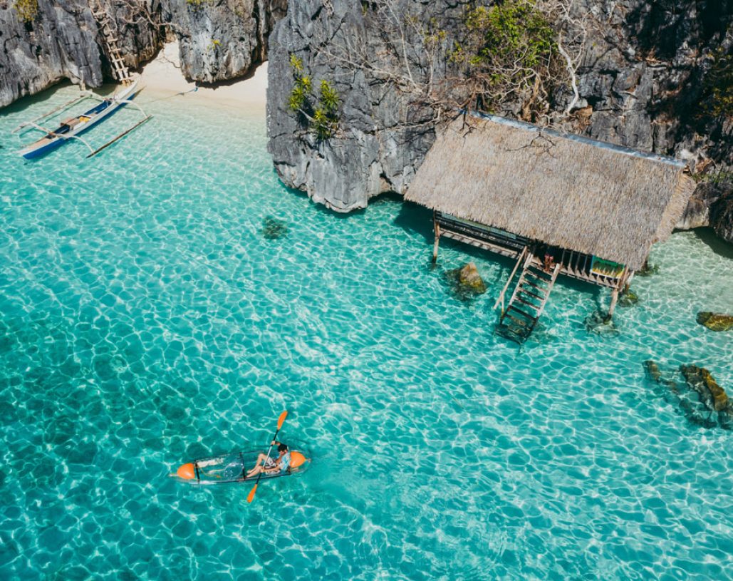 Man kayaking in the twin lagoon between the rocks and fishermen houses, enjoying the landscape